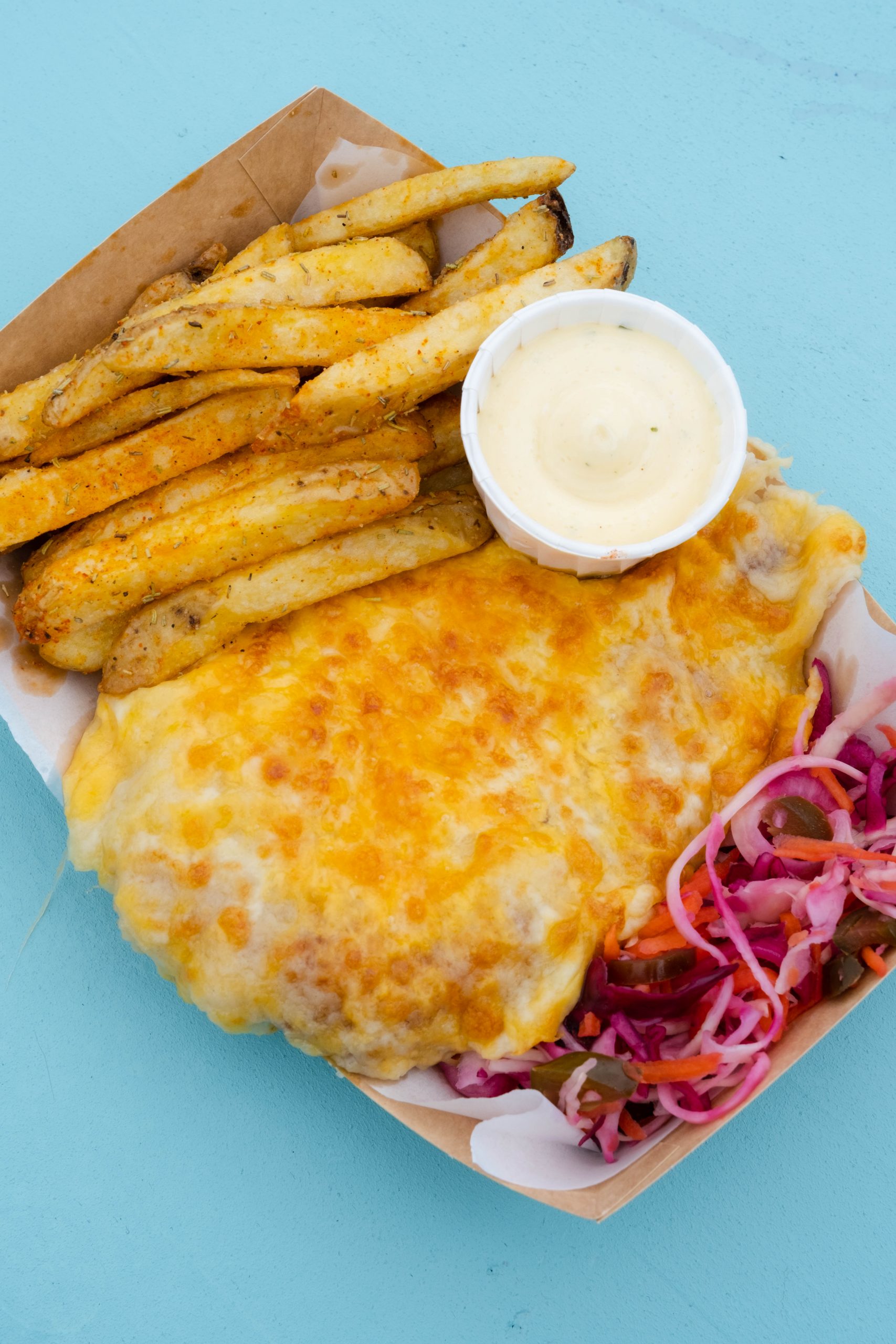 Image shows a Chicken Parmo with chips and a side salad